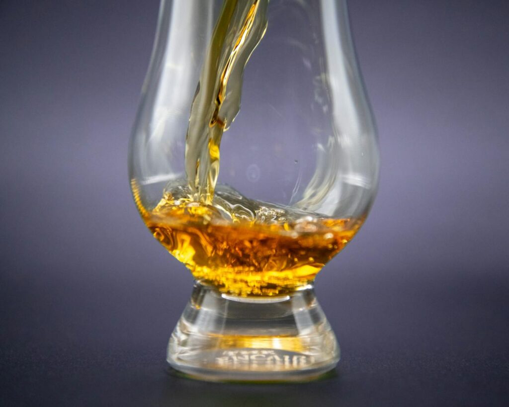 zipwp image 29349921 Close-up of golden whiskey being poured into an elegant glass.