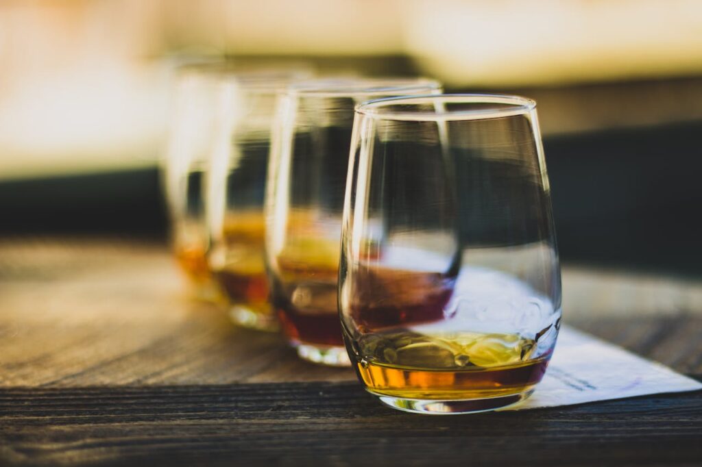 zipwp image 7599324 Elegant close-up of whisky glasses in a luxurious tasting setup, highlighting rich tones and textures.